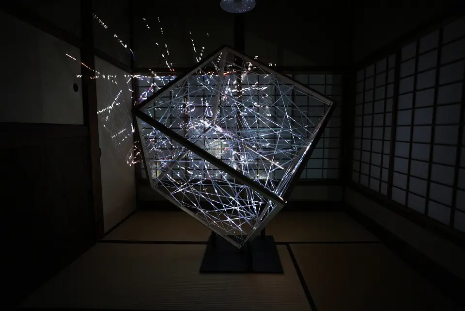 白い光を受けた《layers》の全景。傾けて設置した立方体の内部に糸が張り巡らされ、襖や天井にも光と影が映る。